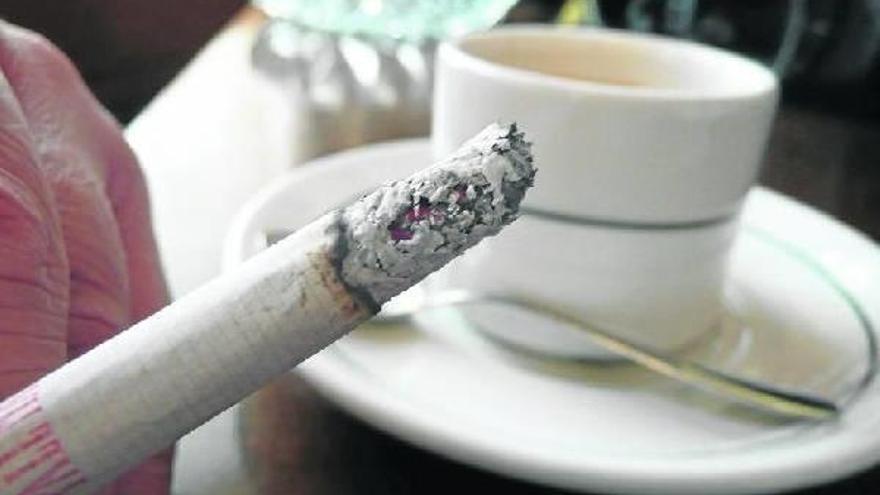 Un hombre acompaña el café con leche del desayuno con un cigarro, un hábito que puede aumentar la posibilidad de sufrir un cáncer.