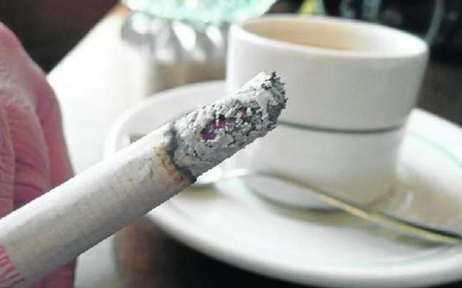 Un hombre acompa&ntilde;a el caf&eacute; con leche del desayuno con un cigarro, un h&aacute;bito que puede aumentar la posibilidad de sufrir un c&aacute;ncer.