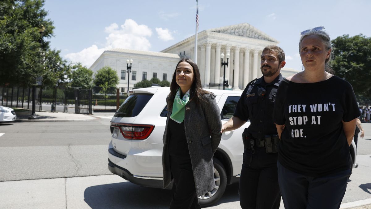 Un agente de la Policía del Capitolio detiene a Alexandria Ocasio-Cortez y a otra mujer.