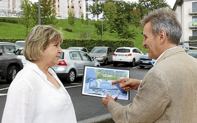 Lourdes Larraza e Iridoy, frente al aparcamiento de Belartza, con un fotomontaje del proyecto. | FOTO: N.G.