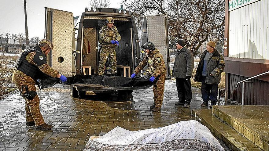 Soldados ucranianos transportan cadávares tras los combates en Bajmut, enclave asediado por las tropas rusas. | FOTO: EFE