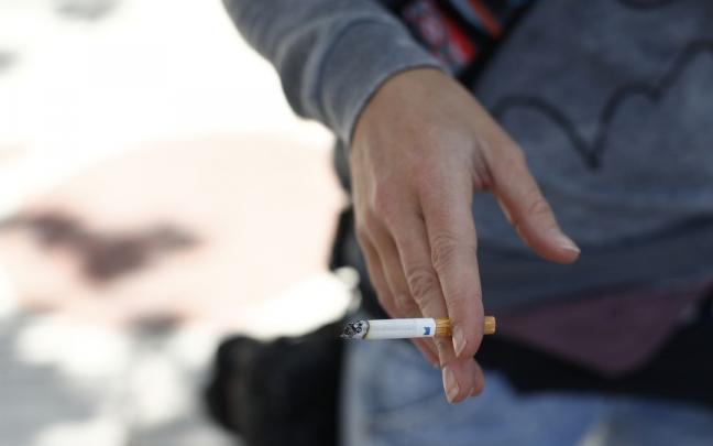 Una persona con un cigarrillo. Una persona con un cigarrillo.