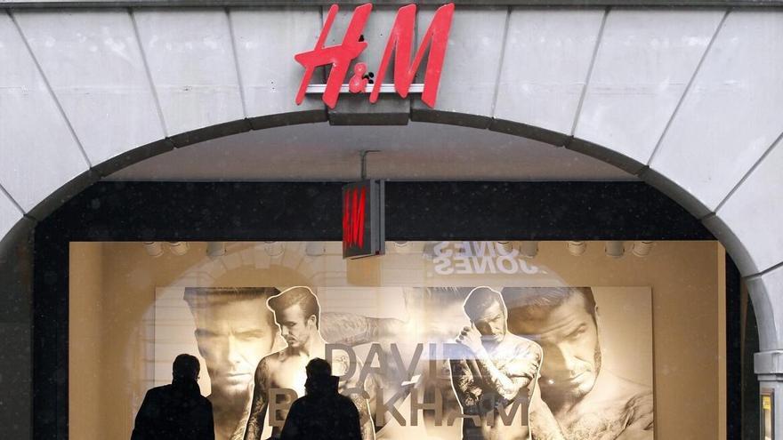 os peatones observan un escaparate de H&M.