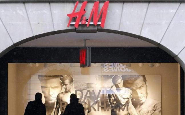 os peatones observan un escaparate de H&M.
