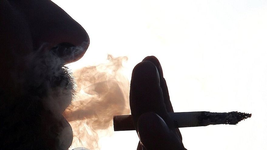 Imagen de archivo de un hombre fumando un cigarro.