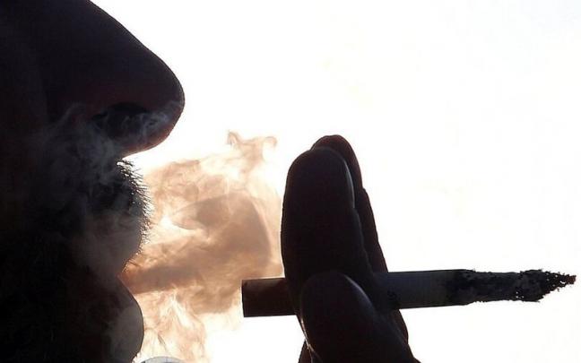 Imagen de archivo de un hombre fumando un cigarro.