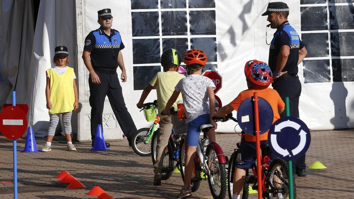 Niños circulando con bicicleta en un taller sobre seguridad vial