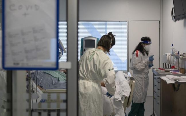 Dos enfermeras atienden a un paciente en la UCI del HUN.