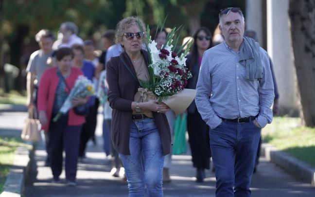 Varias personas caminan con flores por el cementerio de Bilbao. Varias personas caminan con flores por el cementerio de Bilbao.