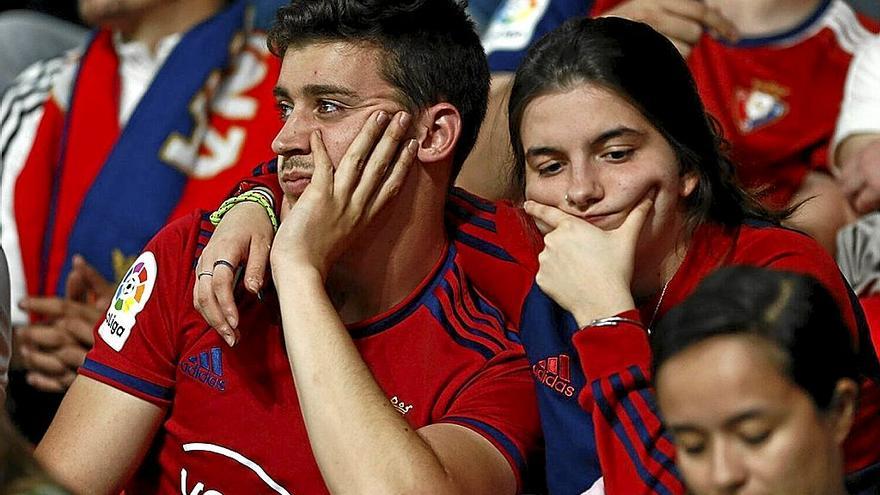Cara de circunstancias en dos aficionados de Osasuna durante el partido de ayer. | FOTO: DIARIO DE NOTICIAS
