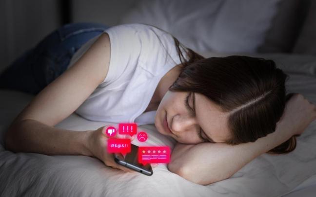 Una joven mira los contenidos de su teléfono móvil