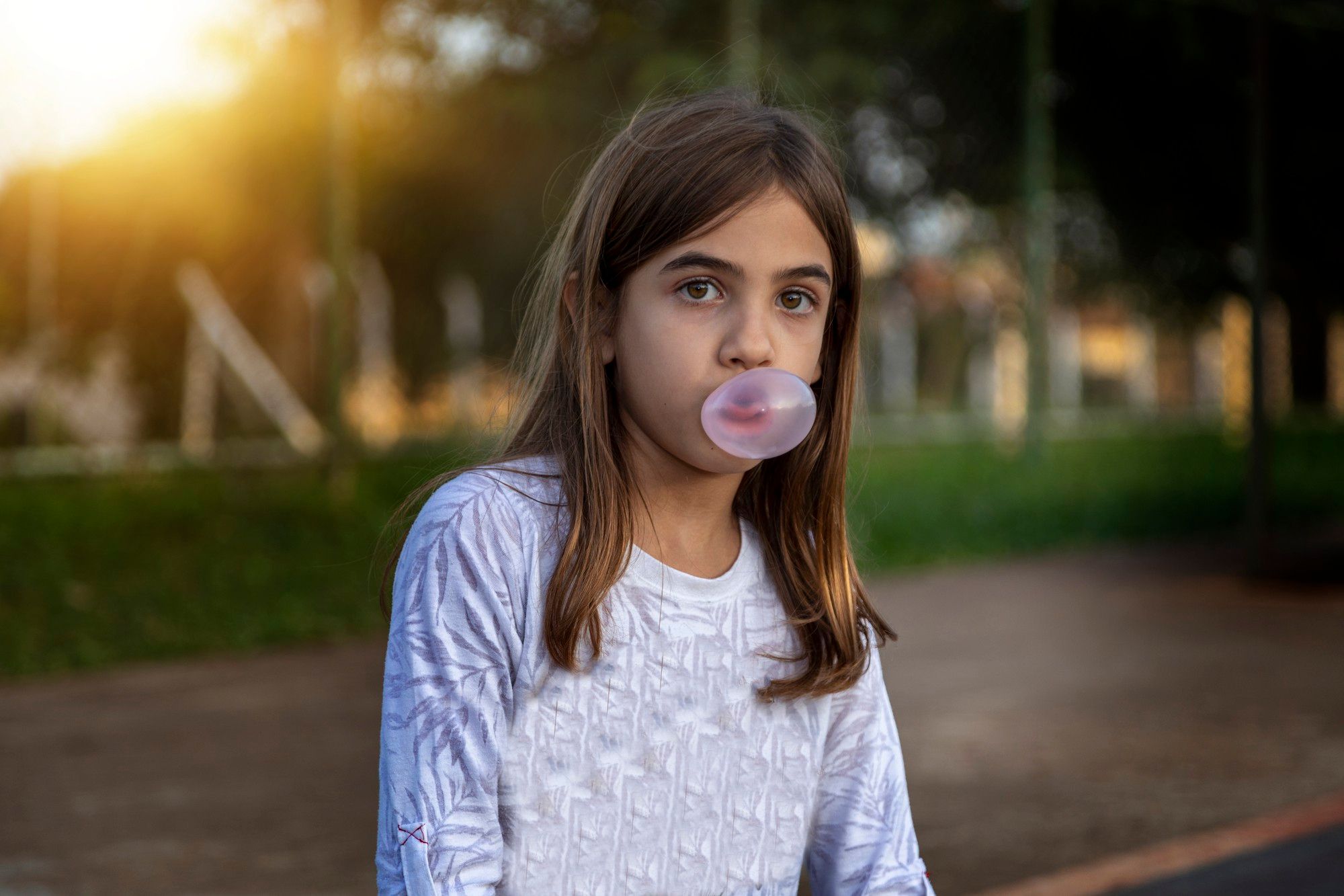 Una niña hace una bomba con un chicle.