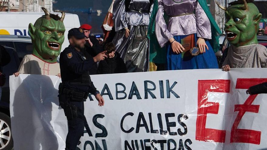 Un agente de Policía Nacional delante de una pancarta en la que se lee “Las calles son nuestras”.