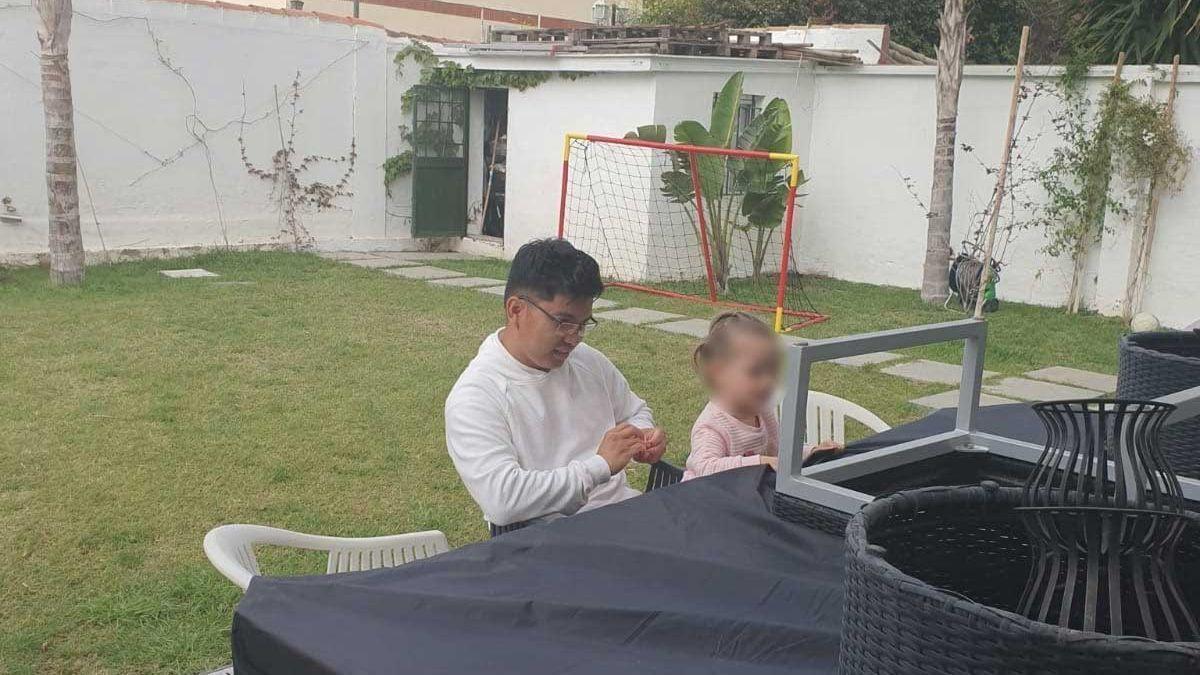 Randolf Roda con una de las niñas a las que cuida en sus labores como empleado del hogar