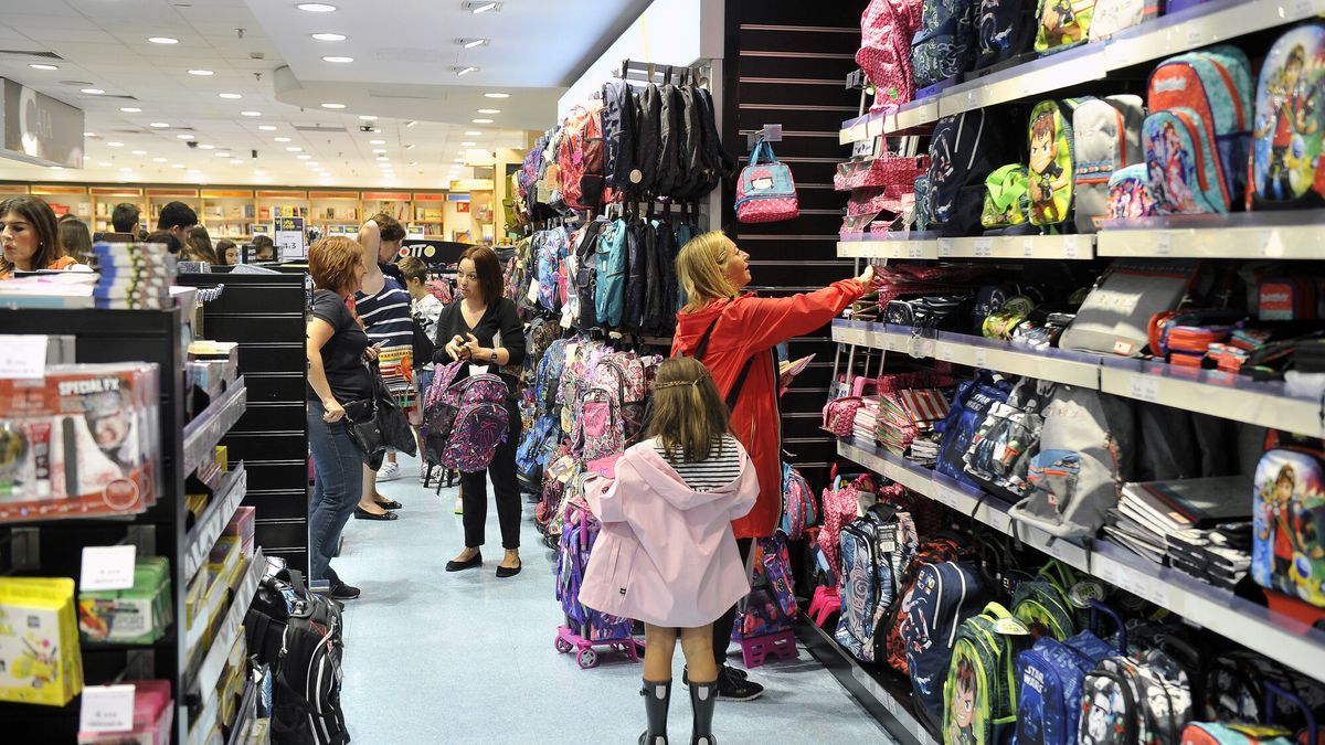 Madres y padres comprando artículos para la vuelta al colegio en septiembre.