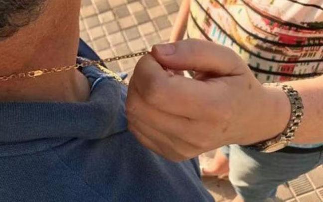 Una ladrona roba la cadena del cuello de una de sus víctimas.
