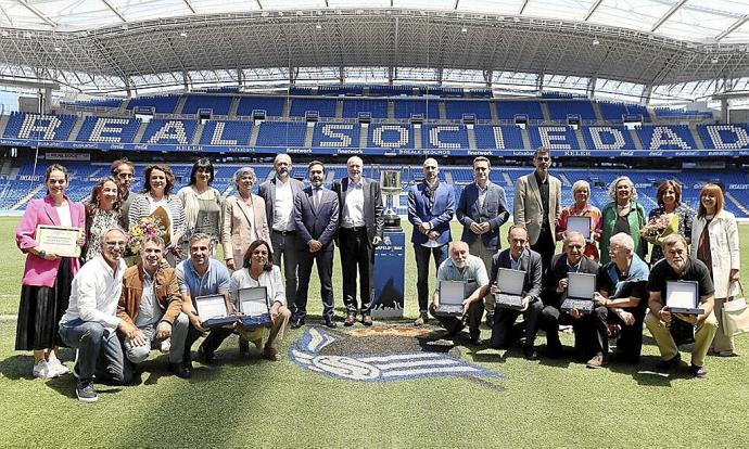 Premiados y homenajeados por la Federación Mercantil de Gipuzkoa posan sobre el verde del Estadio de Anoeta. Foto: Gorka Estrada