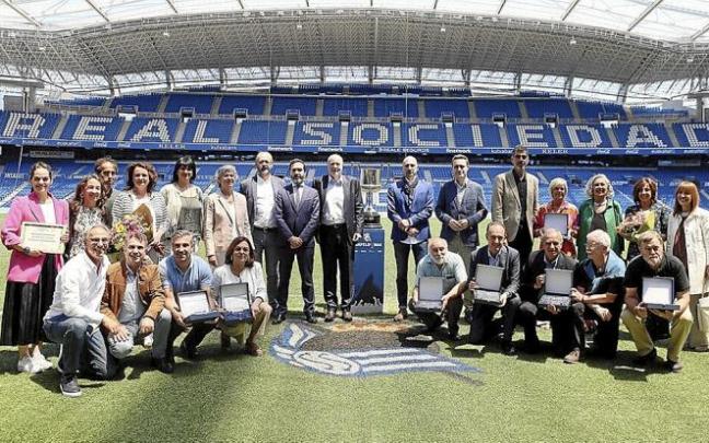 Premiados y homenajeados por la Federación Mercantil de Gipuzkoa posan sobre el verde del Estadio de Anoeta. Foto: Gorka Estrada