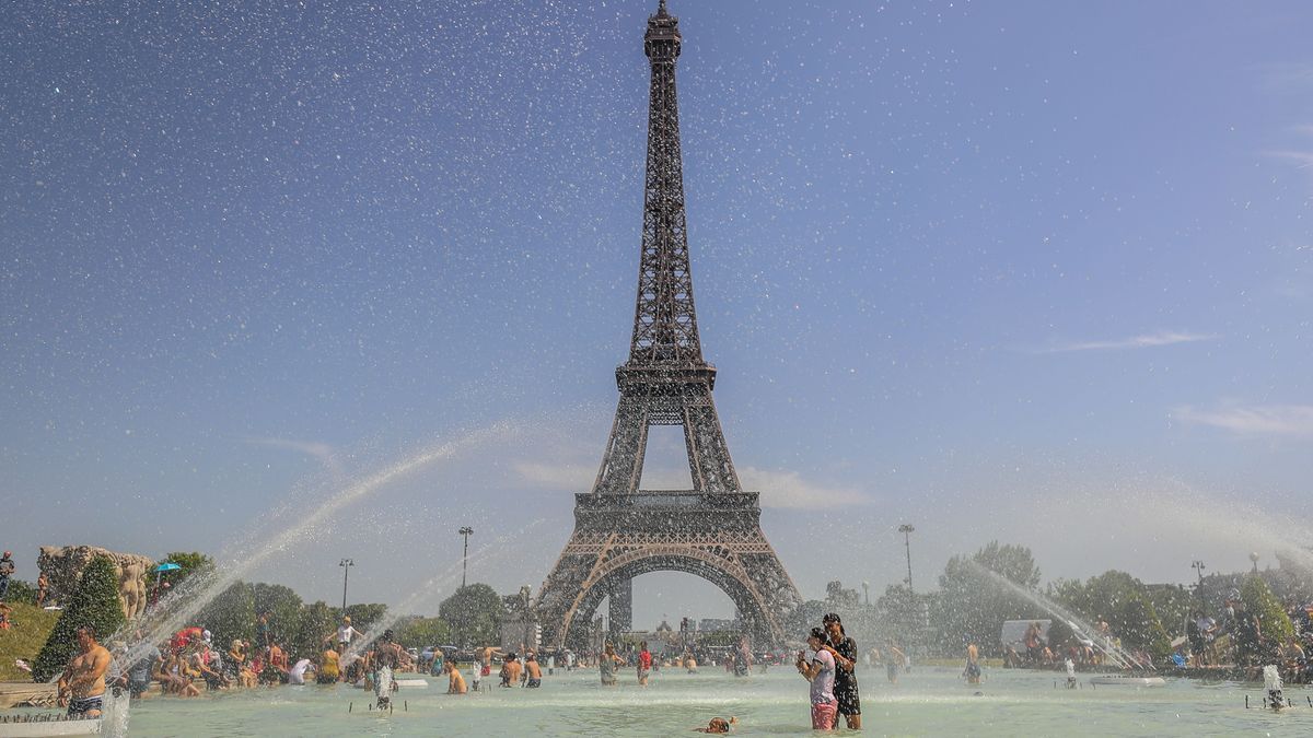 La gente disfruta del agua en la Fuente del Trocadero frente a la Torre Eiffel (París, Francia) durante una ola de calor.