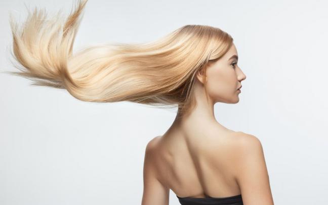 Una mujer luce una larga melena suave e hidratada.