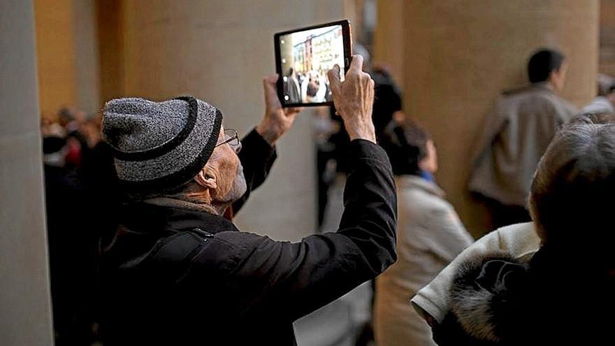 Un hombre mayor hace fotografías con su ‘tablet’. | FOTO: UNAI BEROIZ