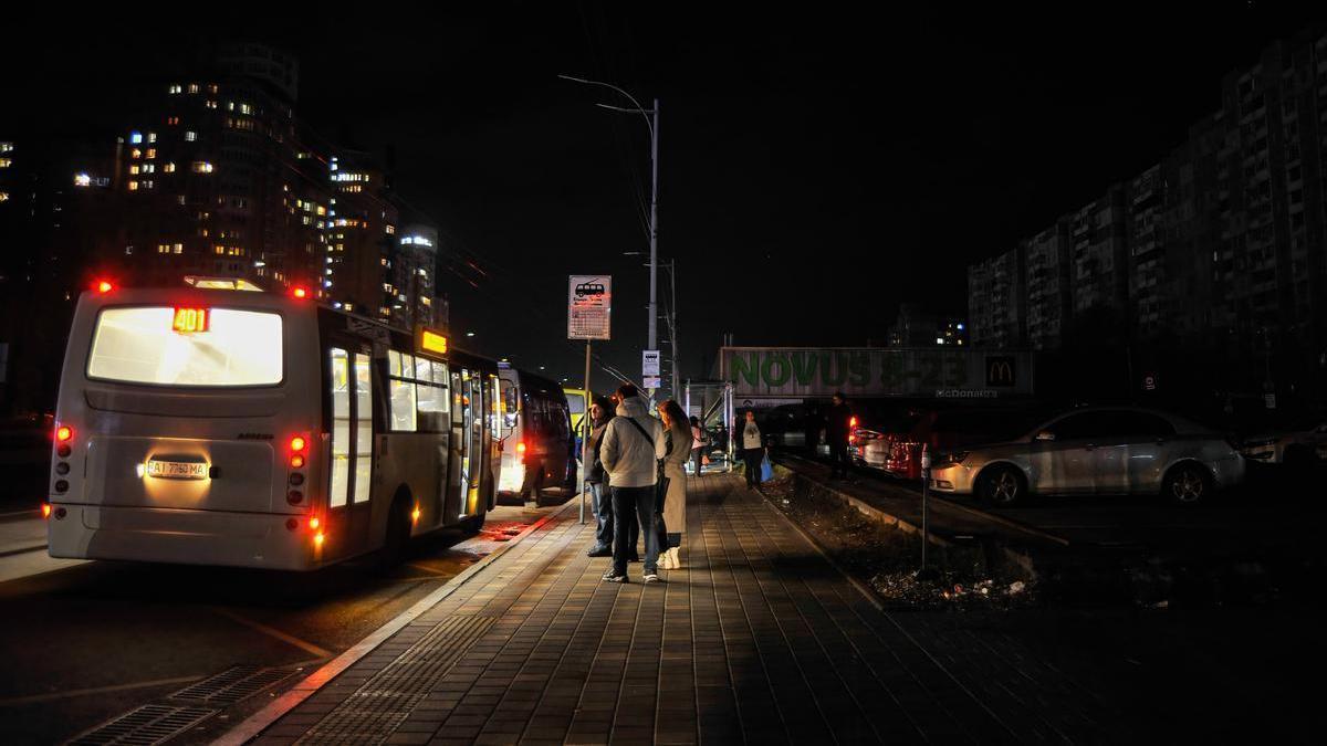 Varias personas hacen cola ante un autobús en Kiev.