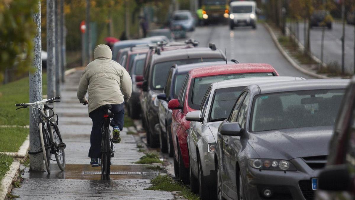 Un ciclista, ajeno a la información, circula por la Avenida de los Huetos