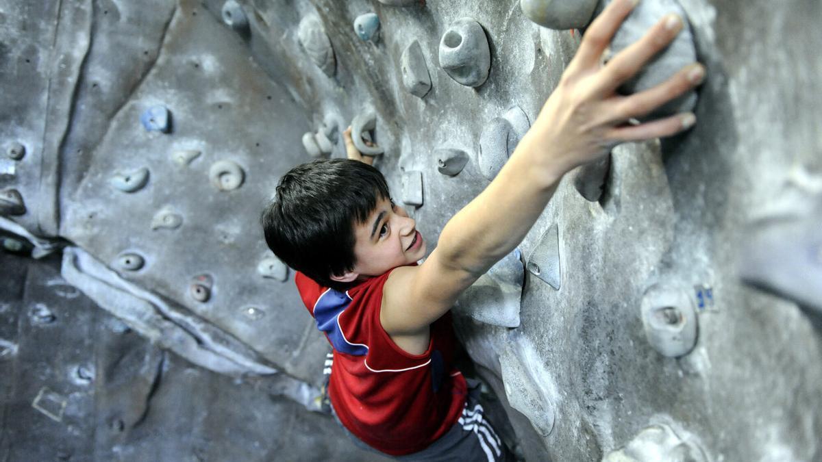 Un joven, en un rocódromo