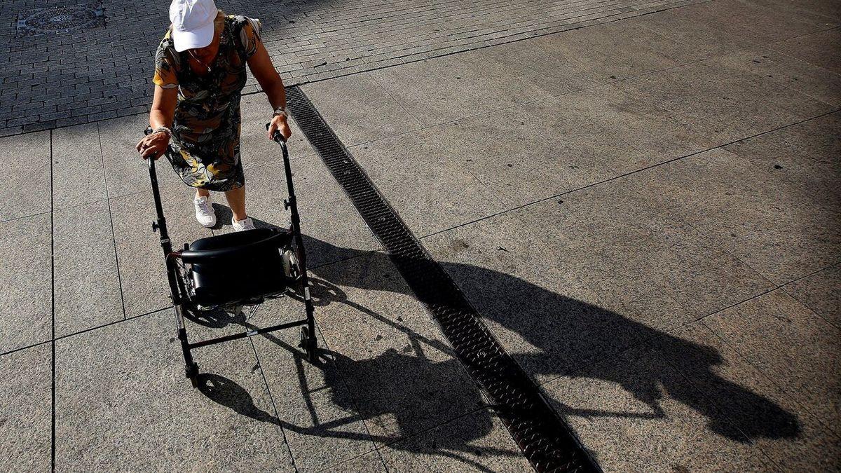 Una mujer mayor paseando con un andador bajo el sol durante una ola de calor.