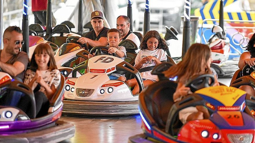 Mayores y niños divirtiéndose en la atracción de los autos de choque.