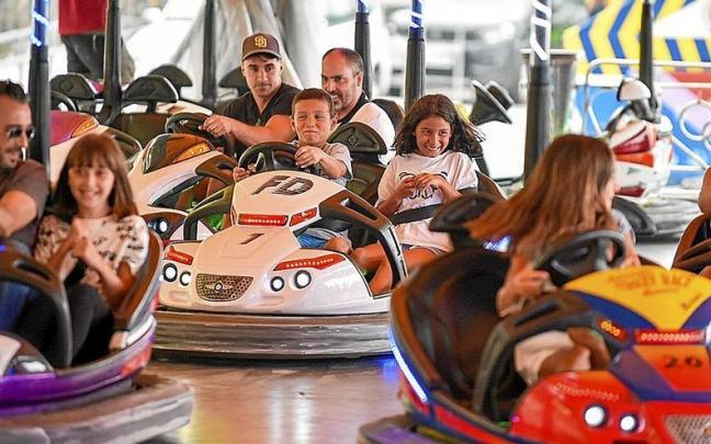 Mayores y niños divirtiéndose en la atracción de los autos de choque. Mayores y niños divirtiéndose en la atracción de los autos de choque.