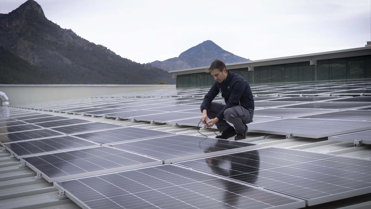 Trabajador de Mercadona en una cubierta de una tienda con paneles solares.