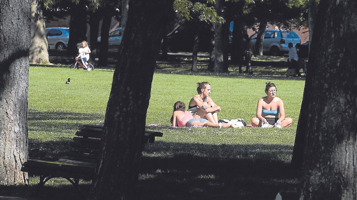 Tres jóvenes toman el sol en la Vuelta del Castillo de Pamplona.