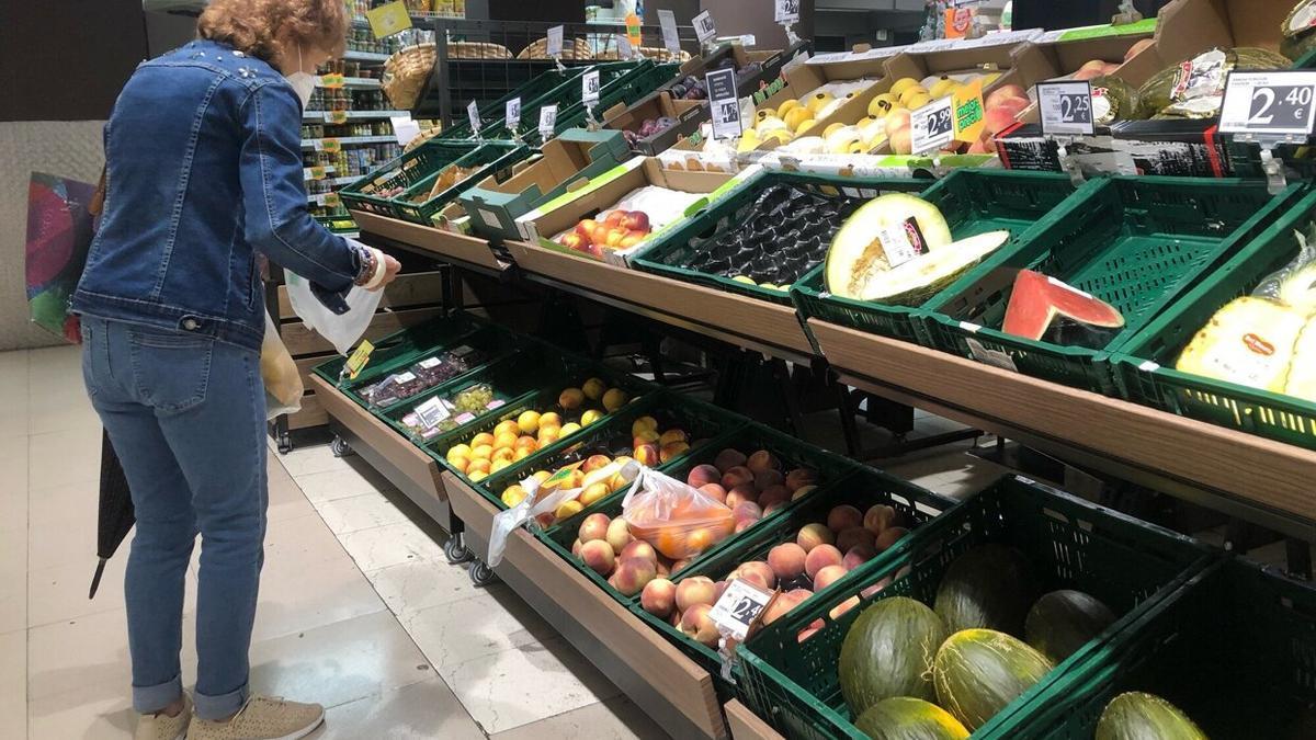 Una mujer realiza la compra en un supermercado de proximidad