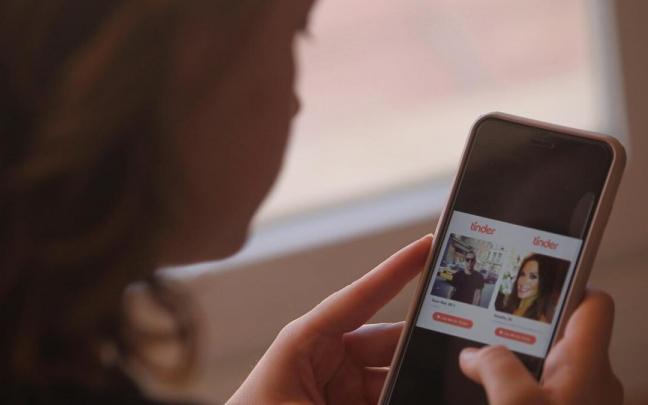 Una mujer utiliza Tinder en su móvil Una mujer utiliza Tinder en su móvil