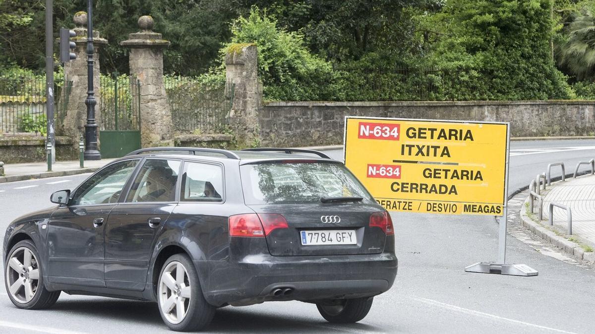 Un coche toma un desvío ante un cartel que avisa del corte de la carretera de la Costa por un desprendimiento anterior