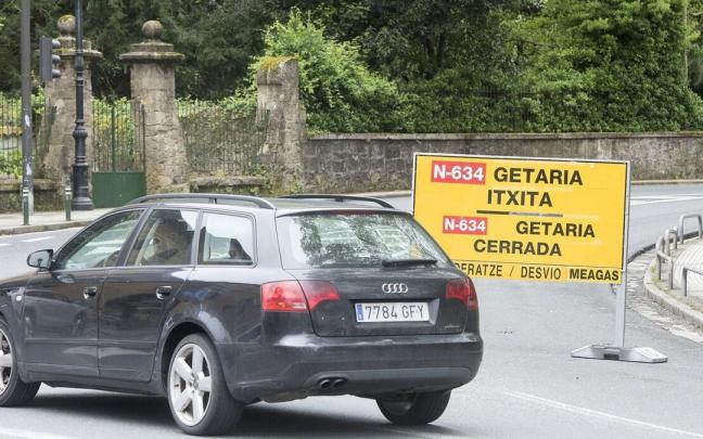 Un coche toma un desvío ante un cartel que avisa del corte de la carretera de la Costa por un desprendimiento anterior