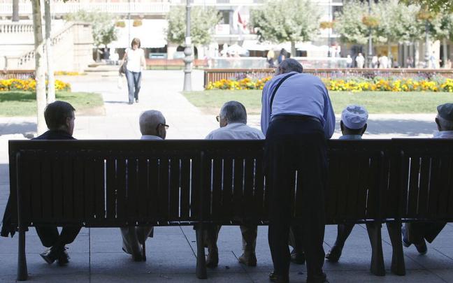 Personas mayores, sentadas en un banco de la plaza del Castillo