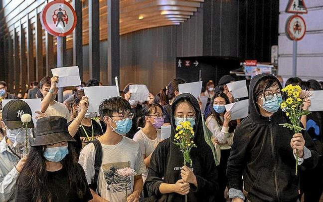 Estudiantes protagonizan una vigilia en Hong Kong en memoria de las v&iacute;ctimas del pasado fin de semana. | FOTO: EFE