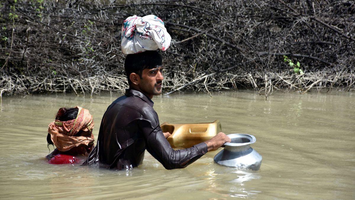 Un hombre y una mujer atraviesan una zona inundada en Karachi, la capital original de Pakistán.