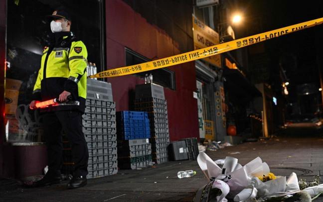 Un agente de polic&iacute;a junto al callej&oacute;n de Itaewon en el que ocurri&oacute; la tragedia.
