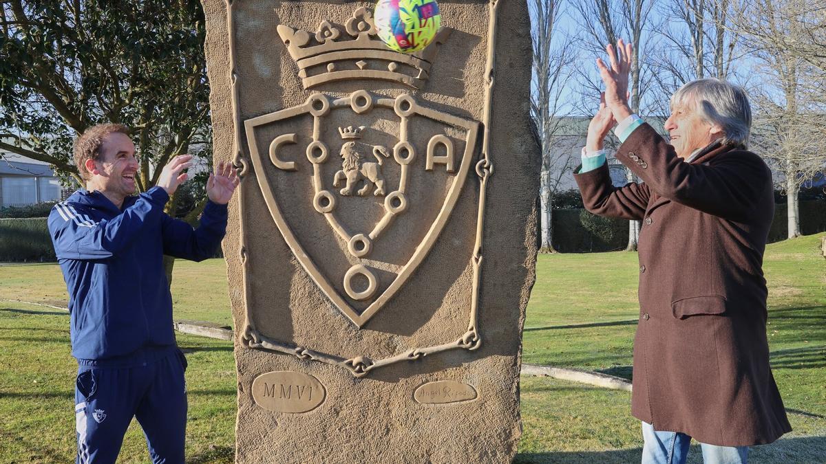 Enrique Martín Monreal le pasa un balón a Jagoba Arrasate delante del monolito con el escudo de Osasuna que hay en Tajonar. Haz clic para ver las fotos del encuentro de entrenadores.