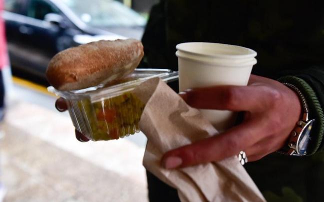 Alimentos entregados a un joven que acude a recibir una cena solidaria.