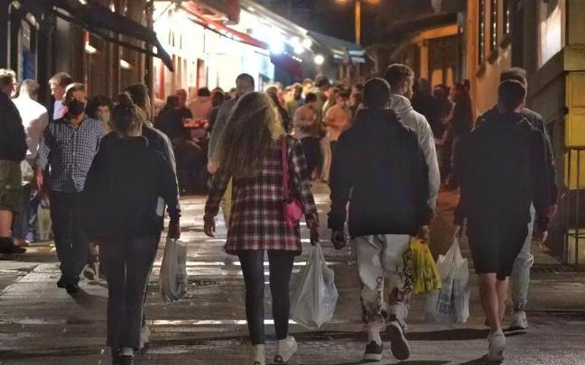 J&oacute;venes con bolsas con bebidas alcoh&oacute;licas.