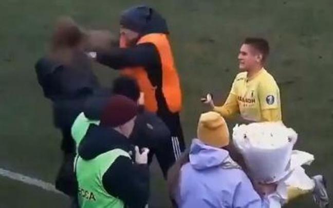 El miembro de seguridad, empujando a la novia ante el futbolista arrodillado. El miembro de seguridad, empujando a la novia ante el futbolista arrodillado.