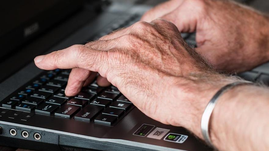 Un hombre escribiendo en el ordenador.