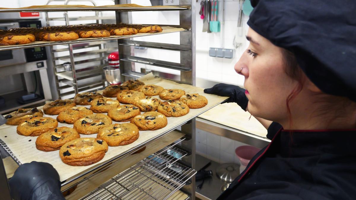 Sheila con una bandeja llena de galletas recién horneadas, en el obrador de la Txantrea.