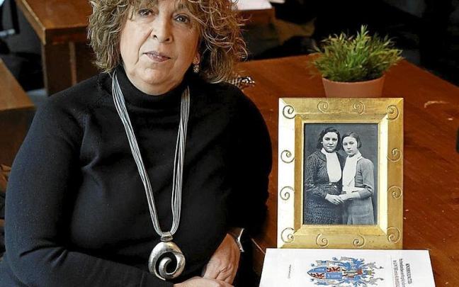 Rosa Ruiz, hija de Lucía Rodríguez Alonso, con un retrato de su madre, a la izquierda. | FOTOS: EFE Rosa Ruiz, hija de Lucía Rodríguez Alonso, con un retrato de su madre, a la izquierda. | FOTOS: EFE