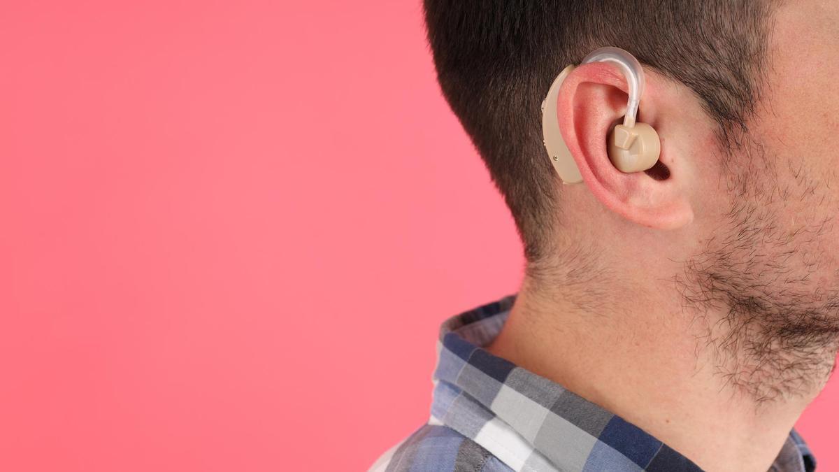 Un hombre joven lleva un aud&iacute;fono en la oreja.