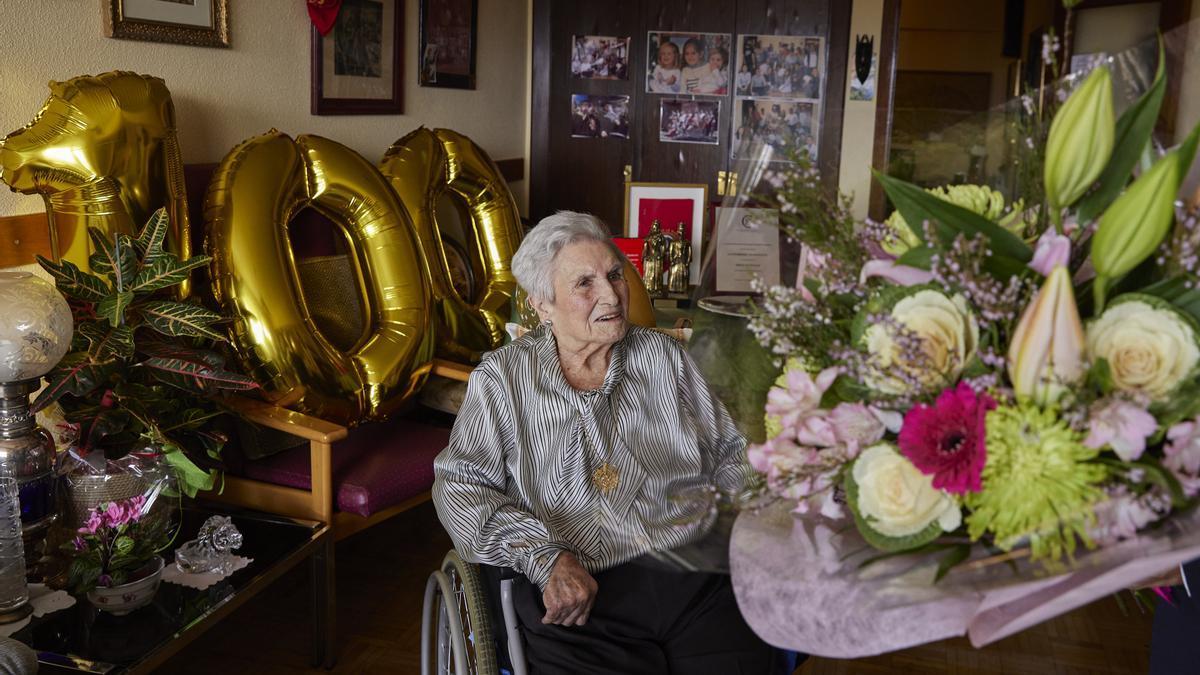 Paulina, en su casa de Iturrama, recibe un ramo de flores en su 100 cumpleaños.